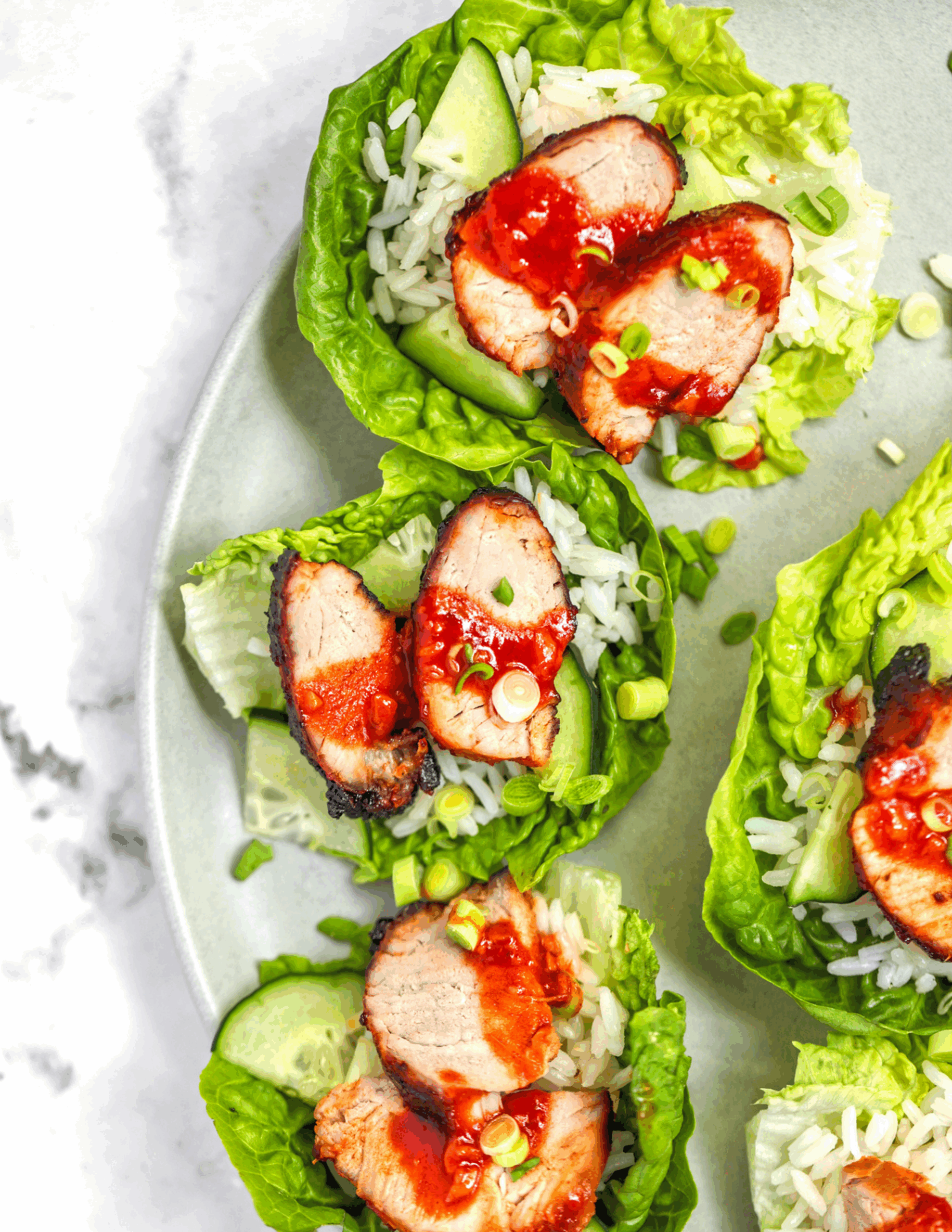 Crispy Korean-style pork served in lettuce leaves with shredded vegetables, sesame seeds, and gochujang sauce