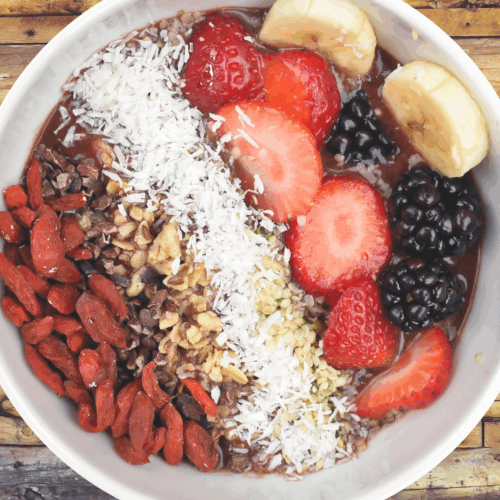 A vibrant acai bowl topped with fresh berries, sliced banana, crunchy granola, chia seeds, and a drizzle of honey, served in a rustic ceramic bowl for a colourful, nutrient-rich breakfast.