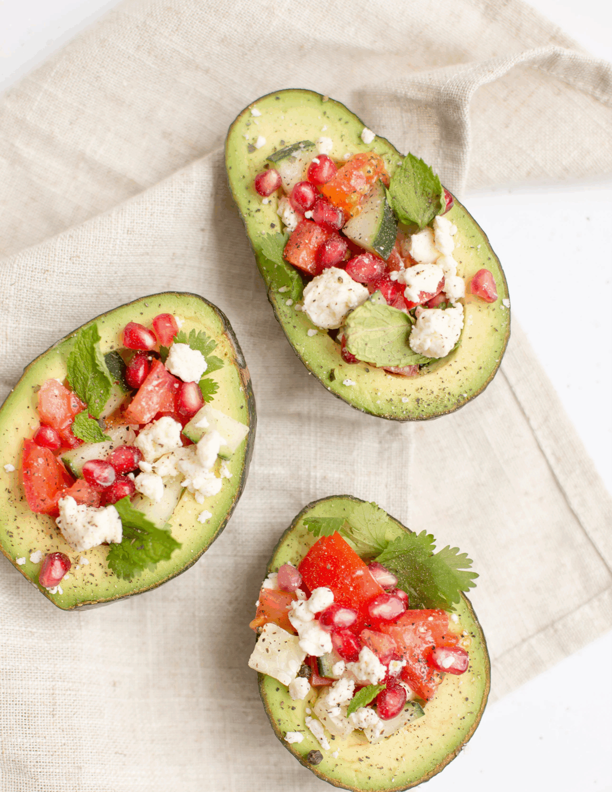 A vibrant plate featuring creamy avocado slices and crumbly feta cheese on crisp wholegrain crackers, garnished with fresh herbs and a drizzle of olive oil for a wholesome, nutrient-rich snack.