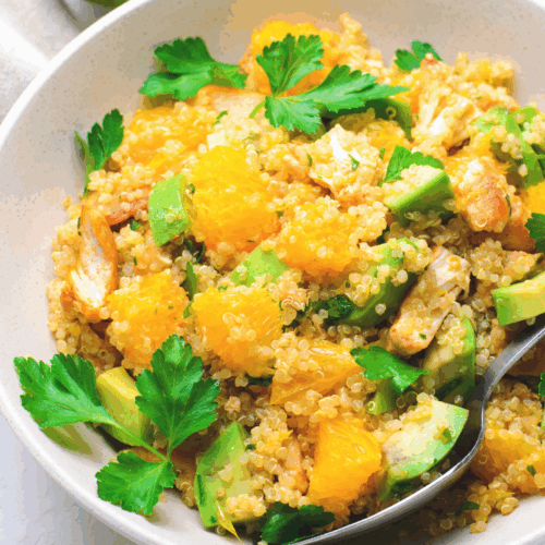 A vibrant bowl of Chicken & Pumpkin Quinoa featuring tender grilled chicken pieces, roasted pumpkin cubes, fluffy quinoa, and fresh herbs, all arranged beautifully on a rustic plate