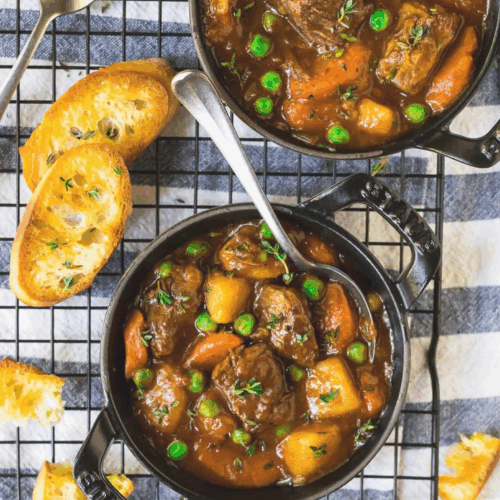 A hearty bowl of Instant Pot Beef Stew featuring tender beef chunks, vibrant carrots, potatoes, and peas, all simmered in a rich and savory broth, garnished with fresh herbs.