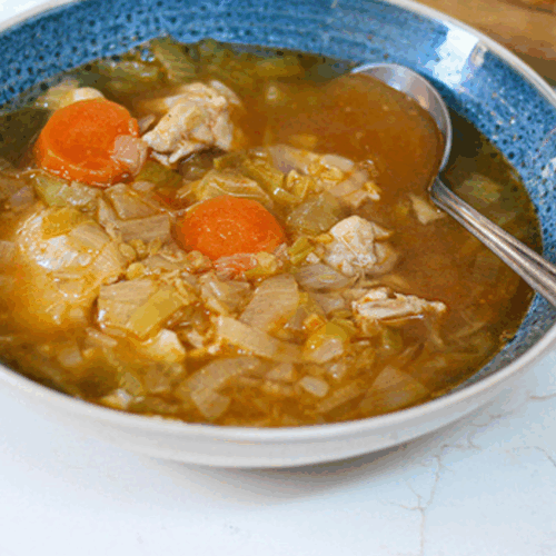 Creamy chicken and lentil soup with tender leeks, shredded chicken, and herbs in a comforting bowl