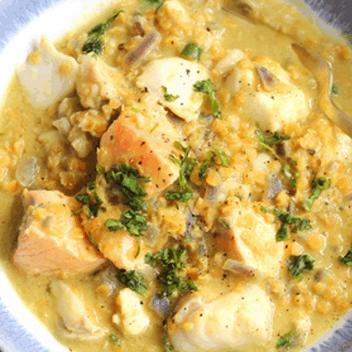 Golden lentil dhal with spiced flaky fish, fresh herbs, and a swirl of coconut yogurt