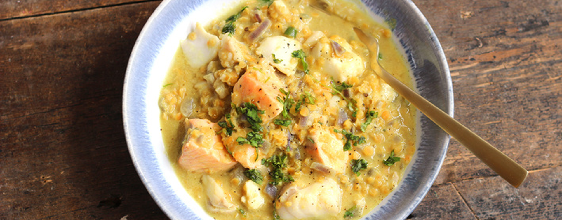 Golden lentil dhal with spiced flaky fish, fresh herbs, and a swirl of coconut yogurt