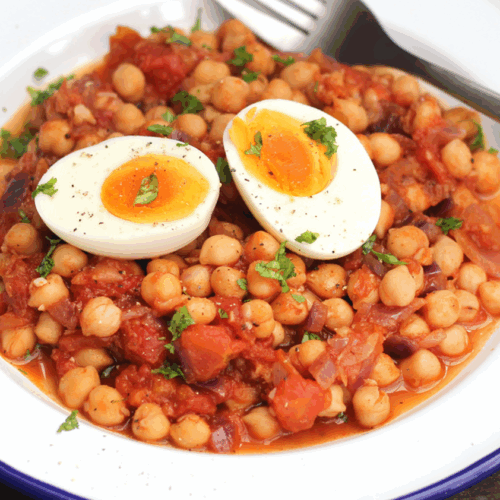 Spiced chickpea hash with roasted vegetables, fresh herbs, and a golden egg topping